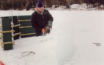 Each block layer was carefully flattened with the saw to assure a tight fit of the next block.  The lifting of the almost 100 lbs block did not look fun, but the result was cool.  He went with the traditional form based wall for a wind break behind the ice wall.