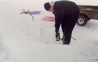 LT somehow got hold of an old ice tongs and, also equipped with a chain saw,  went about harvesting blocks of ice from the lake to build an ice wall.
