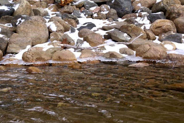 The rocks on the shore all had an ice skirt.