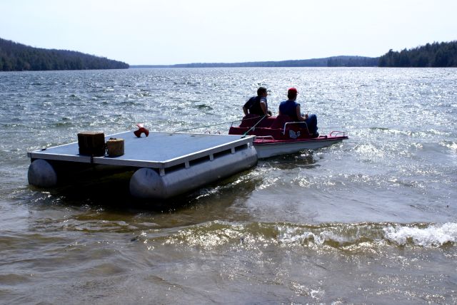 A paddle boat was used to move the raft into position.  The wind and waves on Sunday made this yearly task difficult.  The people who had to go into the water report it as cold, very cold.