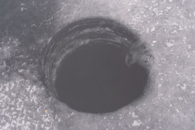 On Sunday, using sore, ski weary muscles, a hole was made in the ice on the lake.  There are 5.5 inches of very clear ice.  It will be much thicker by next weekend.