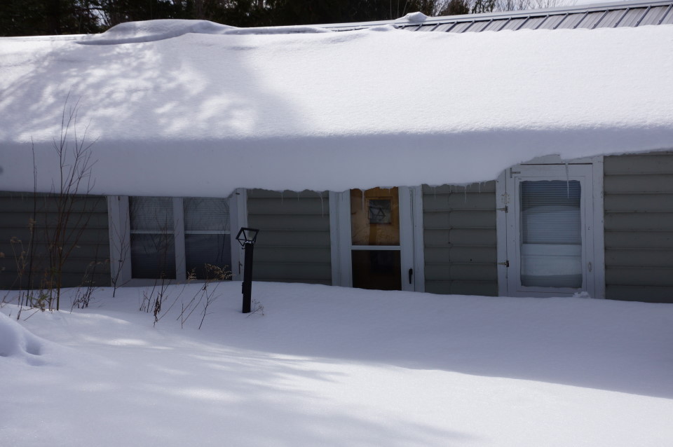 Snow.  When we last left the lake it was present but managable.  Now the bar looks like it's squinting as the snow curling from the roof gets closer to the growing piles on the ground. 