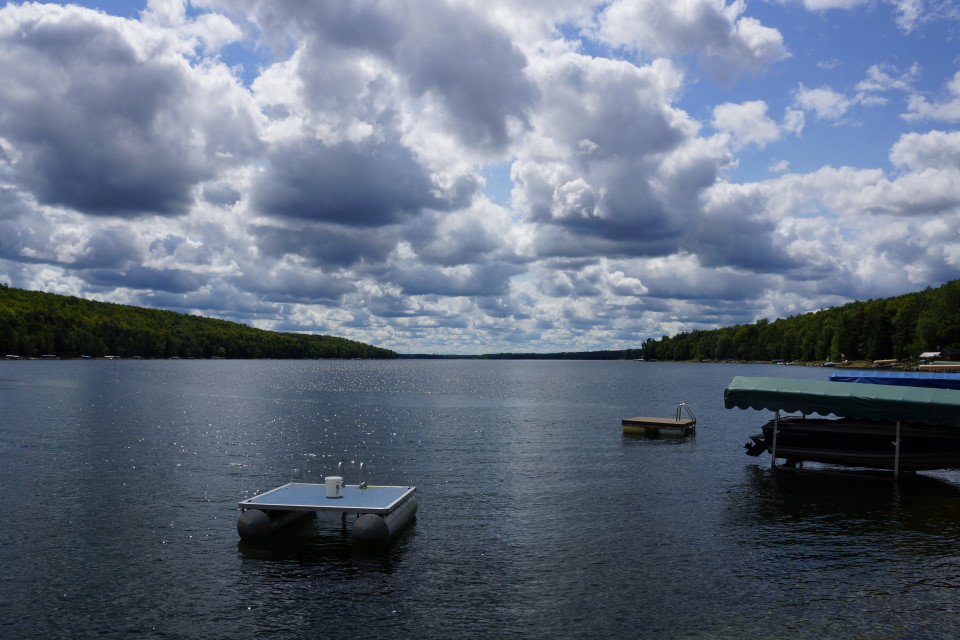 This picture has a bluer sky between white, puffy August clouds, sunlight dancing on the lake,  and that raft with the fish under the pontoons thus tying the end of the summary to the beginning.  I'll let you know which I went with when I figure it out.  I really like the sun dancing on the water and the tying it all together aspect in this second picture but the metaphor thingy is a lot of fun.  An image of some of the changing trees wasn't included in this week's update somewhat because of the strong sense of denial this site has toward the ending of Summer but mostly because we did not take a picture of the red and gold leaves in a few of the trees going into town.  I'll get the picture next week for sure.  Posting it will take a bit of therapy to get over the whole denying the end of Summer thing.<br><br><br>-Nemo, clinging to Summer with both hands