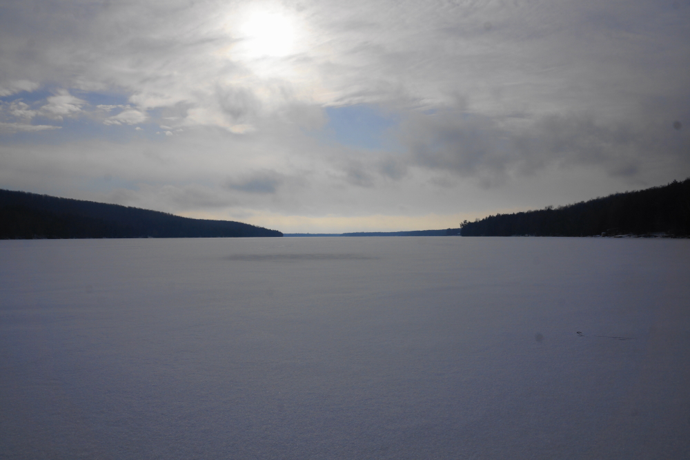 Snow fell early last week. The Lake has yet to get a really big blast, but the 1 to 3 inchers are starting to add up. After all the strong wind, there's only about 2 inches remaining on the lake. Drifts of over 2 feet surround the shoreline and the snowmobile trails are open.