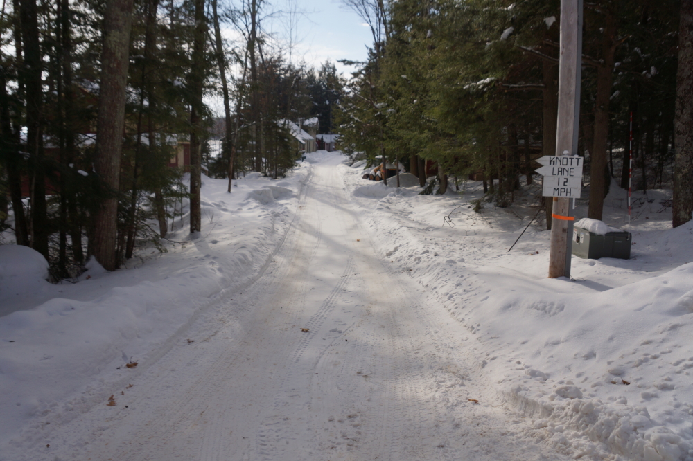 The surface of Knott Lane is different and maybe a little worse. The tree cover prevents the sun from converting the snow cover to slush, but traffic has sintered the white stuff into an ice-like covering anyway.