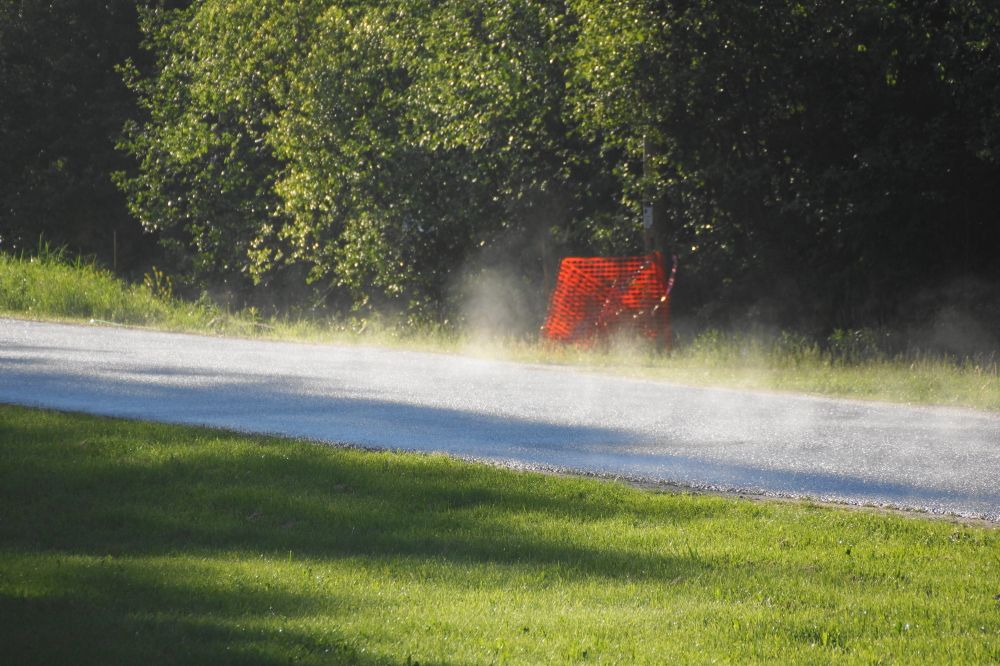 The sun scorched roads dried faster than the en-puddled lawns.