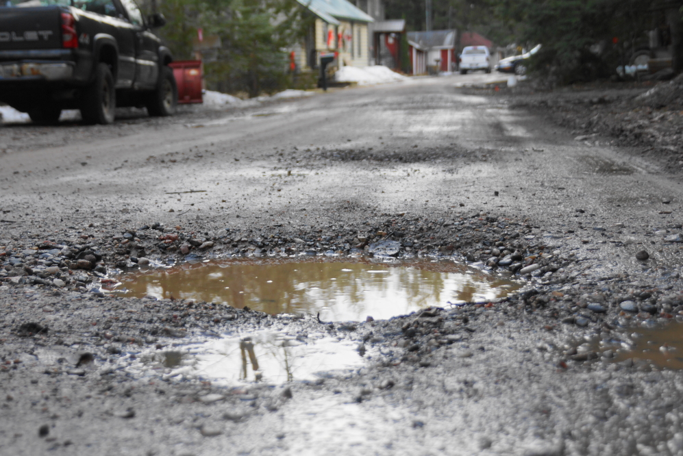 The many puddles on Knott Lane serve as markers for the many potholes that have come to define the road.